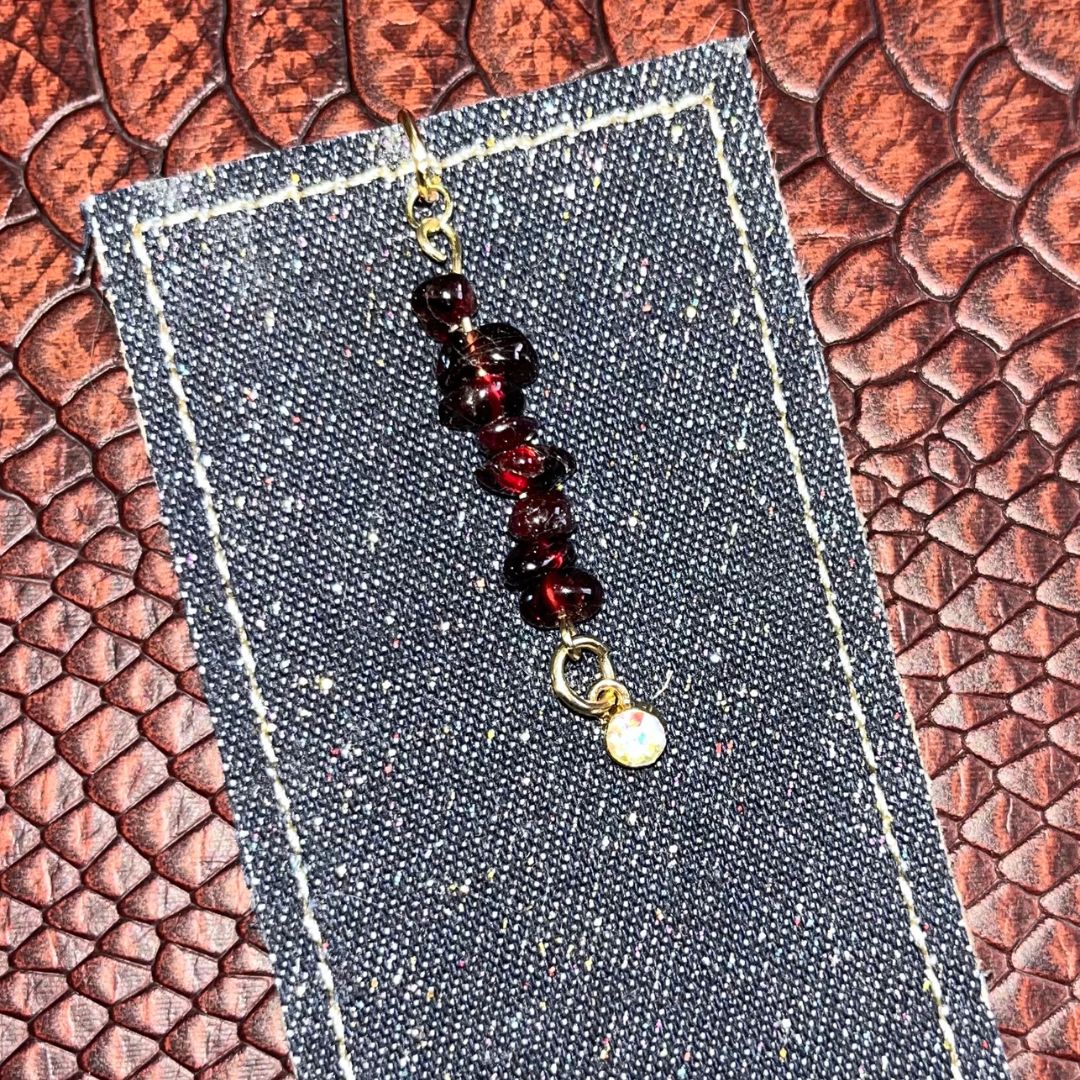 A bookmark with glittery denim and a garnet charm.